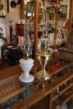 Starožitná mosazná petrolejová lampa ve tvaru poháru se skleněným cylindrem z okolo roku 1910.