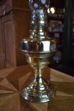 Starožitná mosazná petrolejová lampa ve tvaru poháru se skleněným cylindrem z okolo roku 1910.