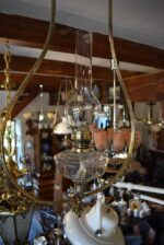 Starožitná secesní petrolejová lampa s prořezávaným mosazným rámem z okolo roku 1900.