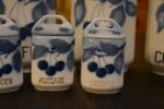 Starožitná sada teplických porcelánových kořenek s modrými třešněmi a francouzskými nápisy.