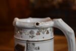 Starožitný žertovný porcelánový půllitr s výjevem z Prodané nevěsty a prolamovaným okrajem.