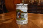 Starožitný žertovný porcelánový půllitr s výjevem z Prodané nevěsty a prolamovaným okrajem.