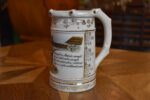 Starožitný žertovný porcelánový půllitr s výjevem z Prodané nevěsty a prolamovaným okrajem.