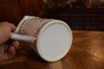 Starožitný žertovný porcelánový půllitr s výjevem z Prodané nevěsty a prolamovaným okrajem.